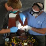 Dr. providing dental care to a woman in Togo.
