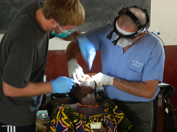 Dr. providing dental care to a woman in Togo.